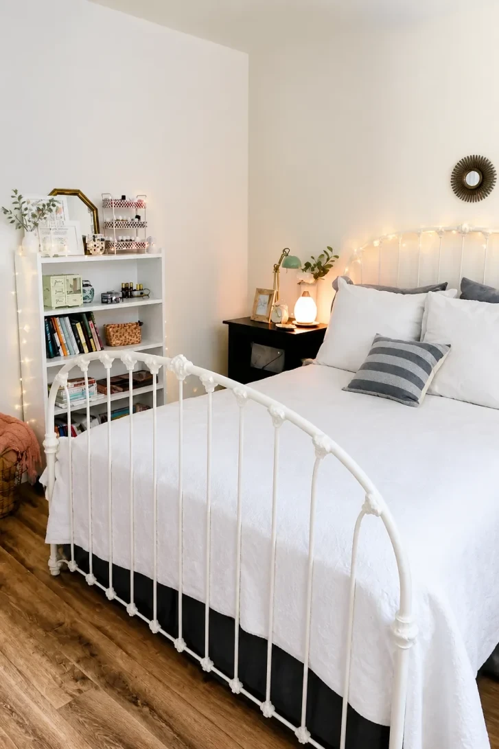 Fairy Lights Draped Across a White Iron Headboard